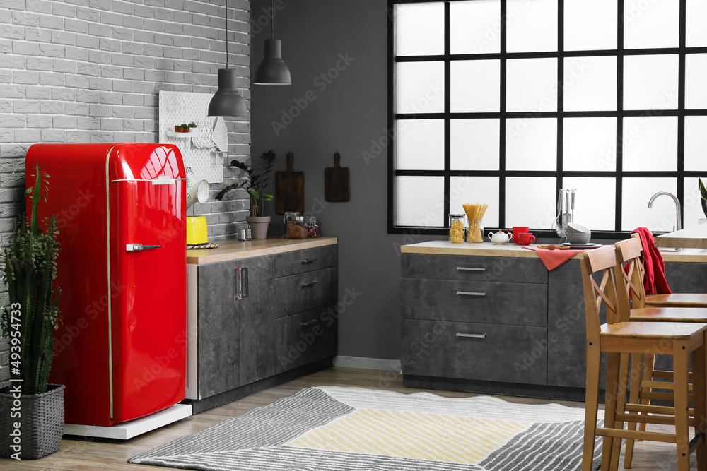 Interior of modern kitchen with stylish refrigerator and counters