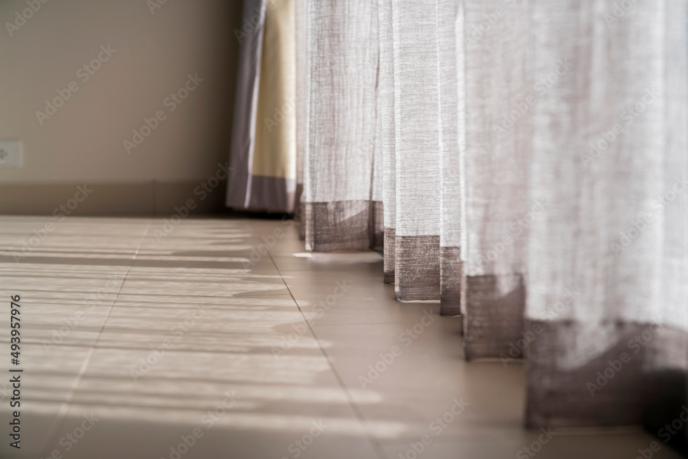 close up white sheer curtain with sun light with shadow shade on wooden floor home interior design c