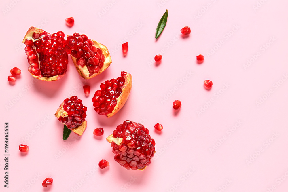 Tasty ripe pomegranate pieces on pink background