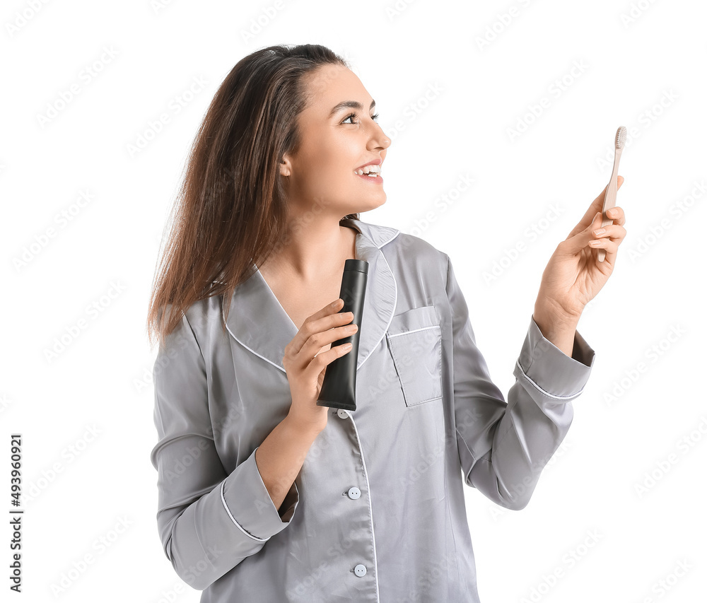 Beautiful young woman with activated charcoal tooth paste and brush on white background