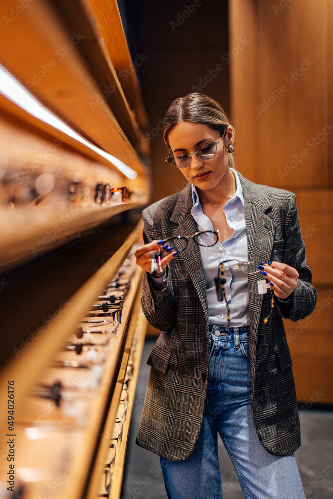 年轻女子，在眼镜店寻找一副好眼镜。