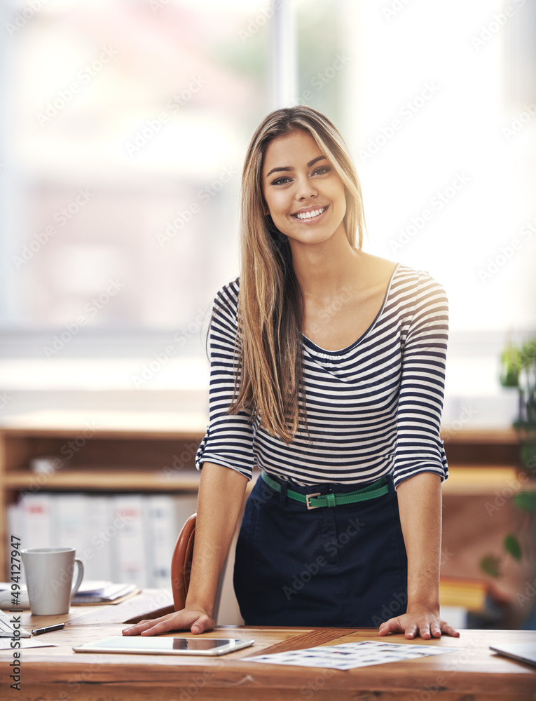 Welcome. Please have a seat. Cropped portrait of a young businesswoman standing behind her desk in t