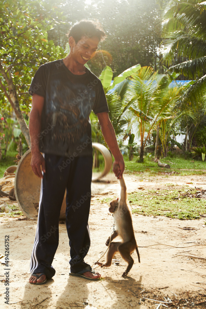 Walking hand in hand. A Thai trainer holding the hand of his monkey - Copyspace.