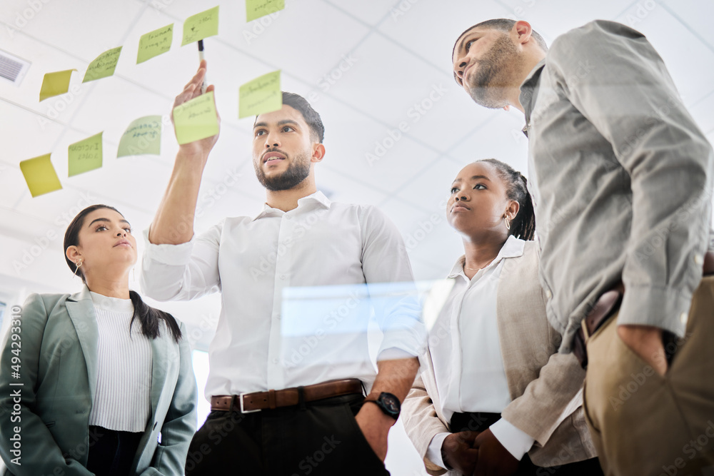 Setting the right strategy in place. Low angle shot of a group of businesspeople brainstorming toget