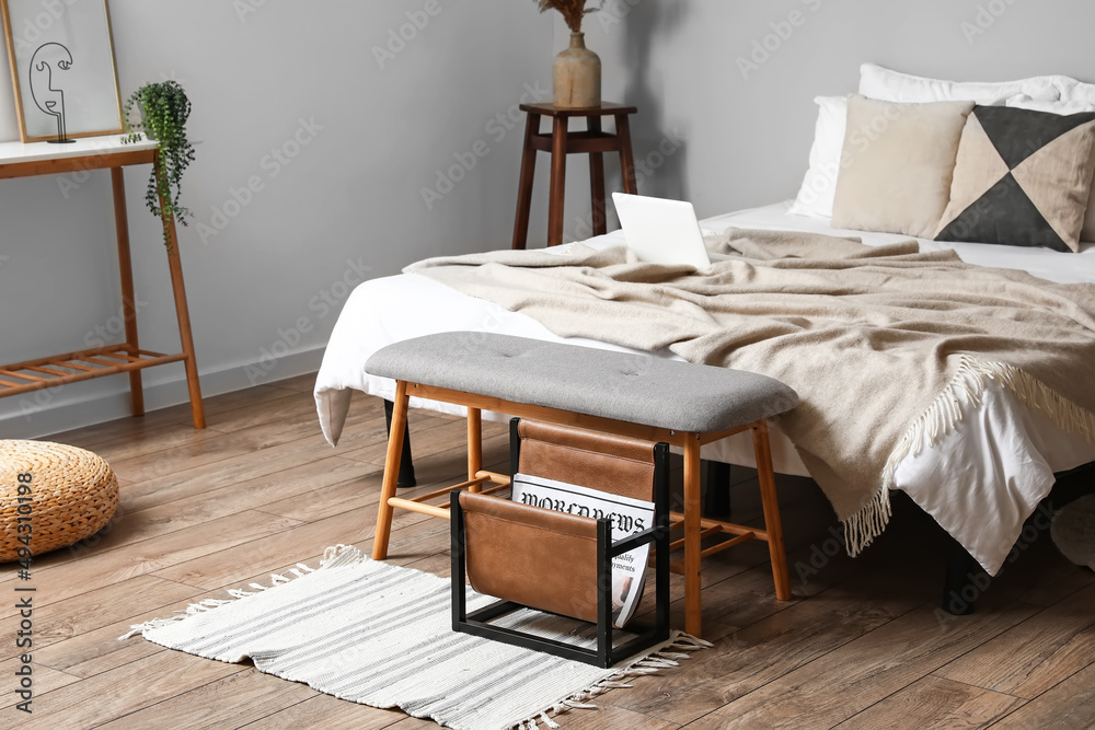 Stylish interior of bedroom with comfortable bed and bench