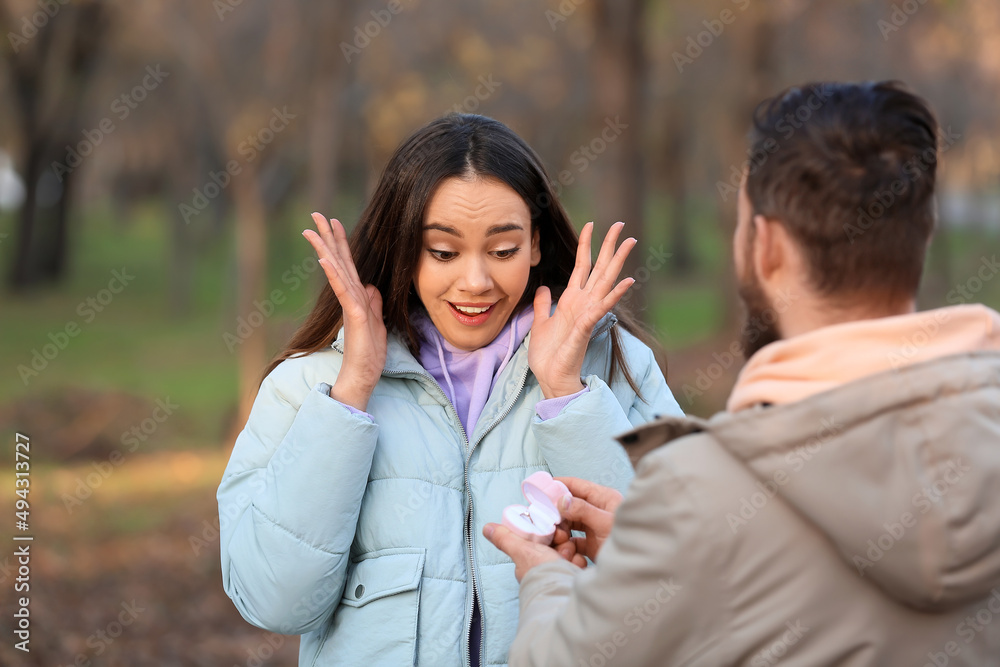 一名年轻男子在森林里向他惊讶的女友求婚