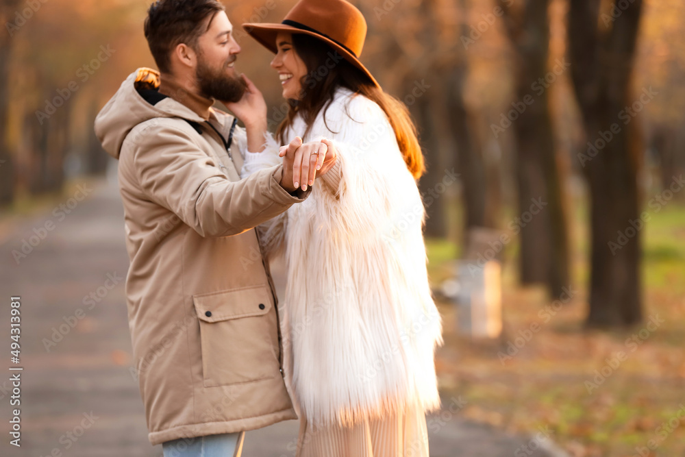 带着订婚戒指的快乐年轻女子和她的未婚夫在公园里