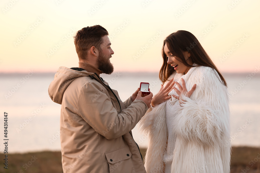 一名年轻男子在河边向他心爱的女孩求婚