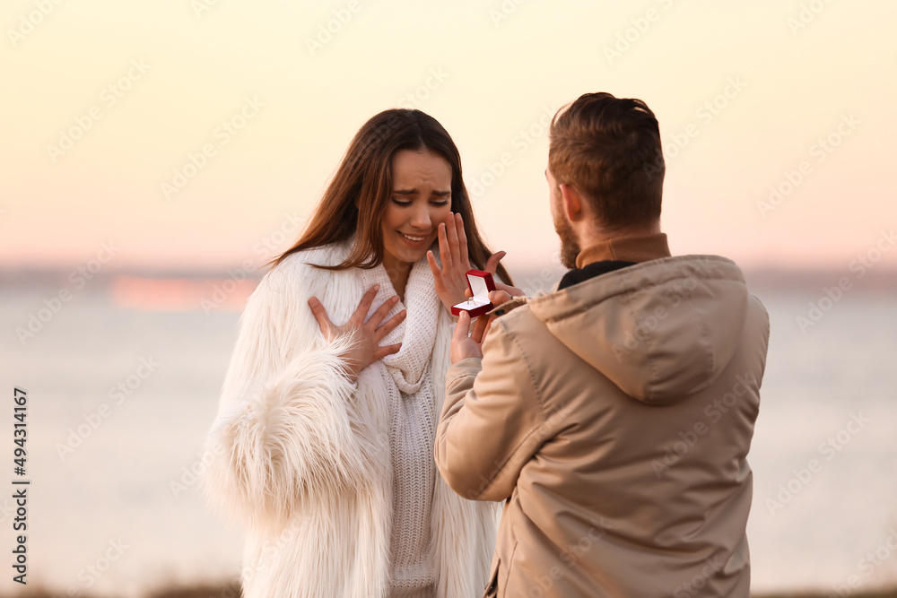 年轻人在河边向他心爱的女孩求婚