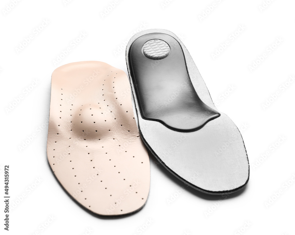 Beige orthopedic insoles on white background