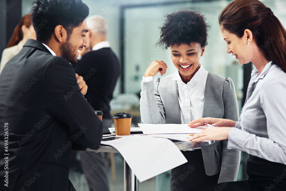 Everybody is on the same page. Shot of a group of businesspeople talking together while sitting at a