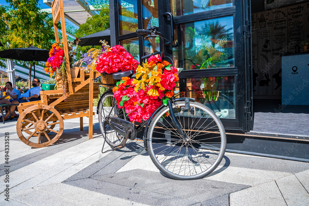 Bicycle with flowers decoration outside restaurant on sunny day, Vintage bike with bouquet flowers a