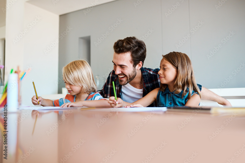 They just love when their daddy is around. Shot of a young father helping his two small children wit