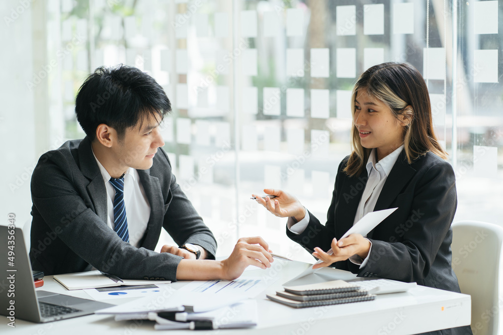 Businesspeople smiling coworking commenting and showing growth graphic and taking a business convers