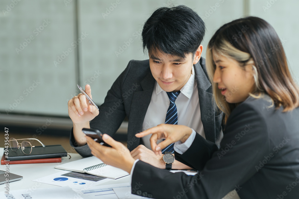 Two colleagues discussing data with tablet and new modern computer laptop on desk table. Close up bu