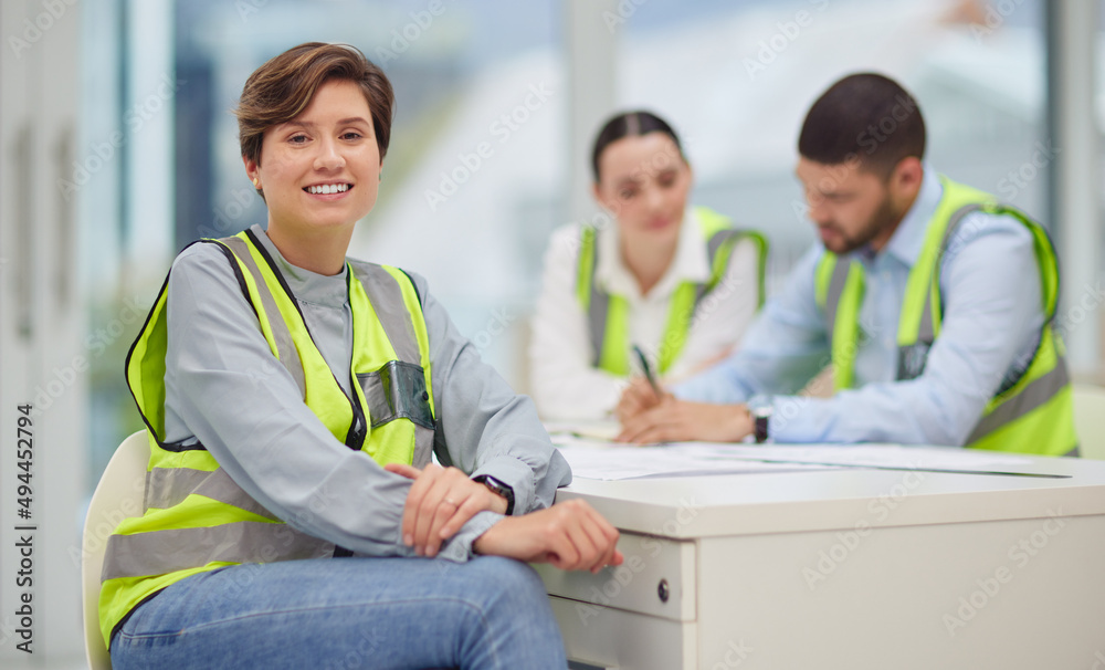 我们有大计划。一位漂亮的年轻女建筑工人坐在街上的裁剪肖像