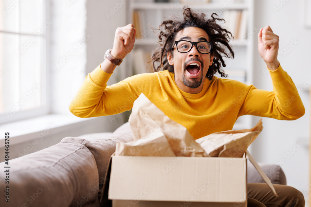 African American man cheering about delivered parcel