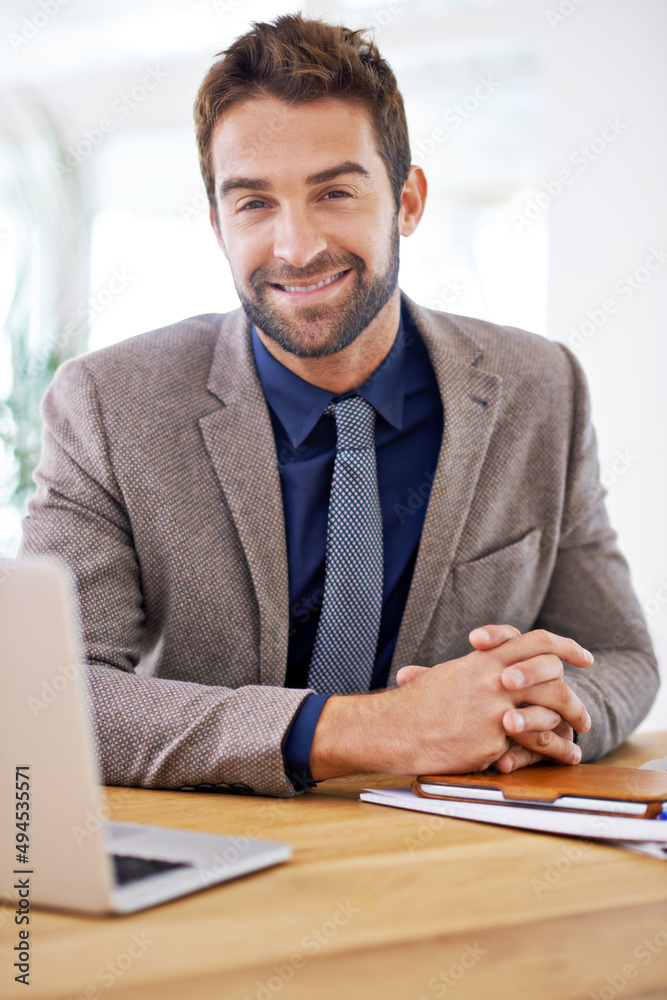 Always at your service. Shot of a young man sitting in his office.