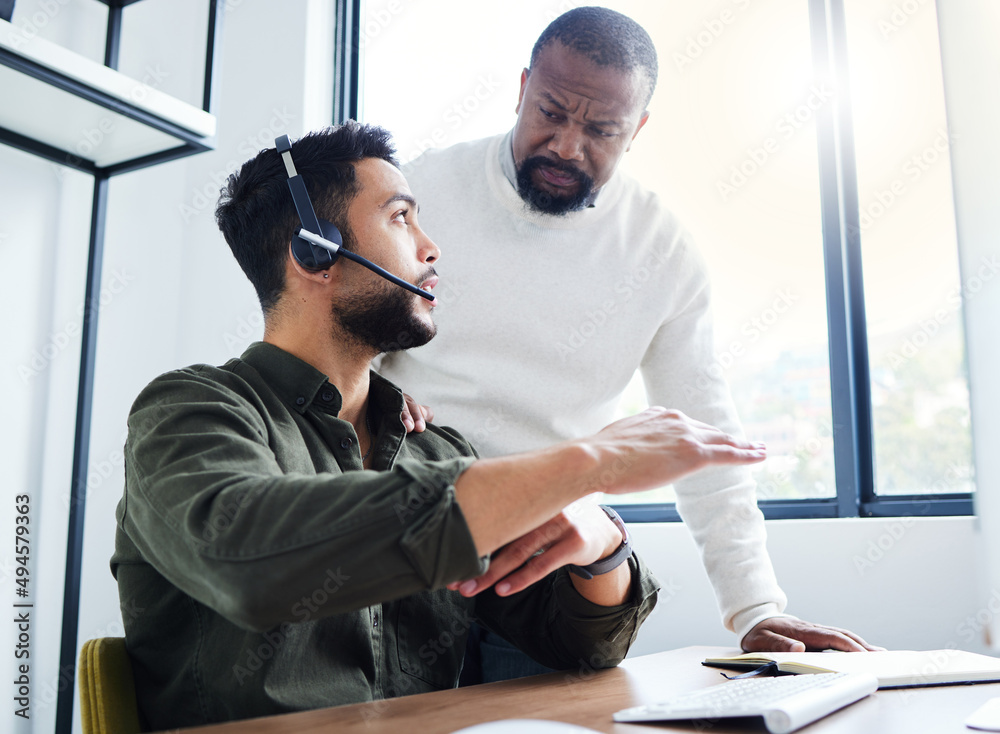 Well solve this together. Shot of a young male call center worker receiving direction from his boss.