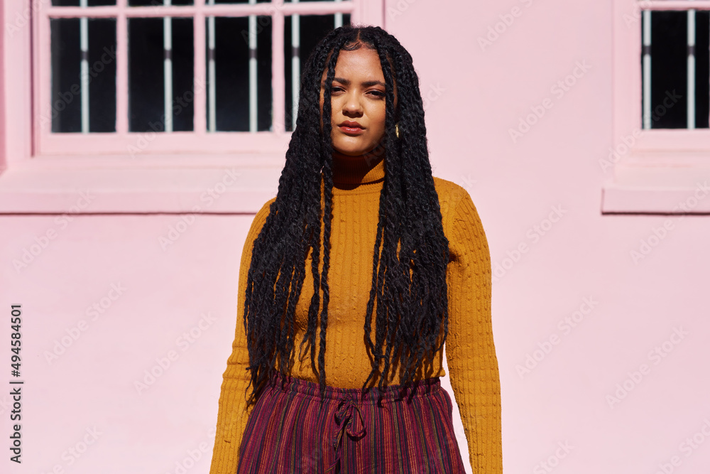 Self-confidence is the best outfit. Shot of a beautiful young woman posing against a pink wall.