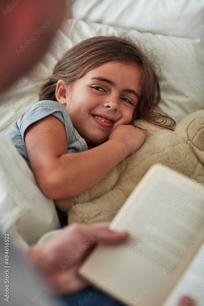 Did they end up happily ever after. Cropped shot of a little girl lying in bed while her father read