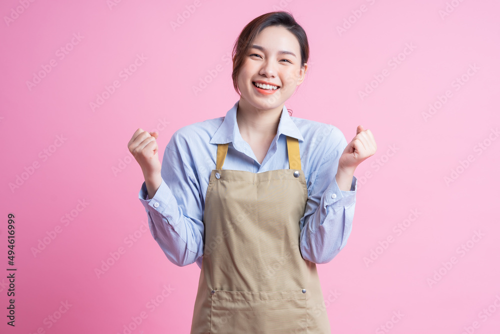 站在粉色背景上的年轻亚洲女服务员