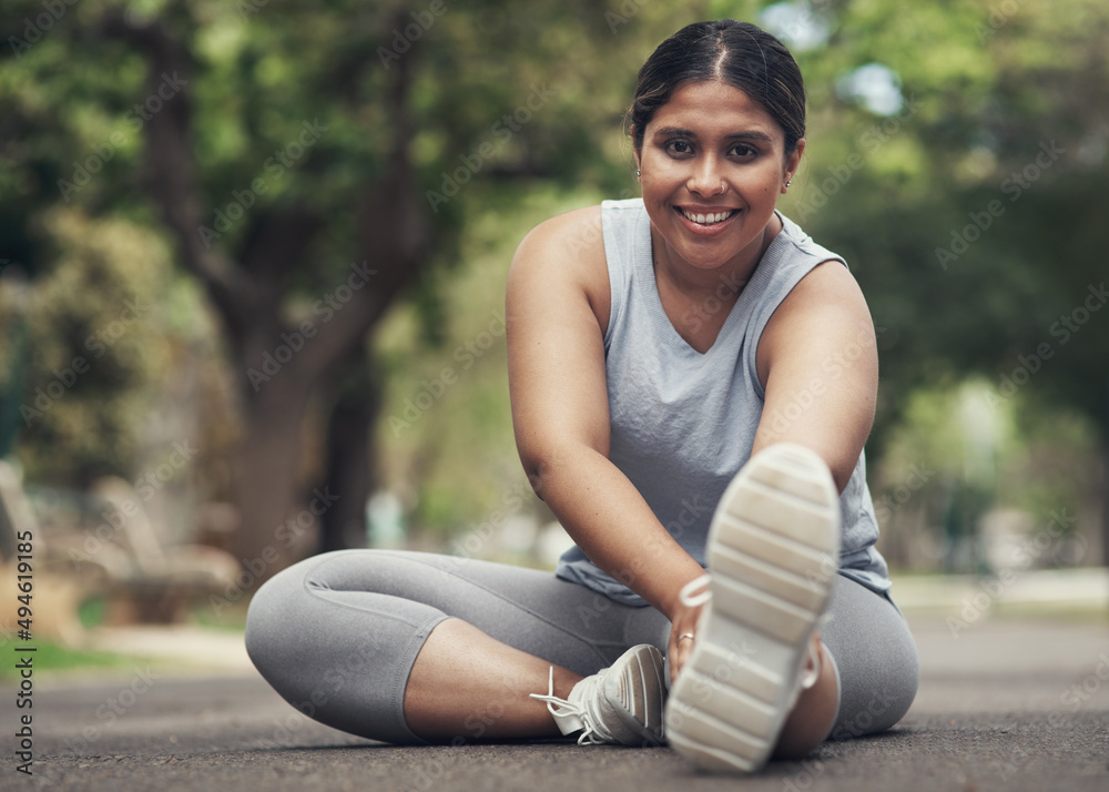 Make sure you stretch first. Shot of a young woman stretching before working out.