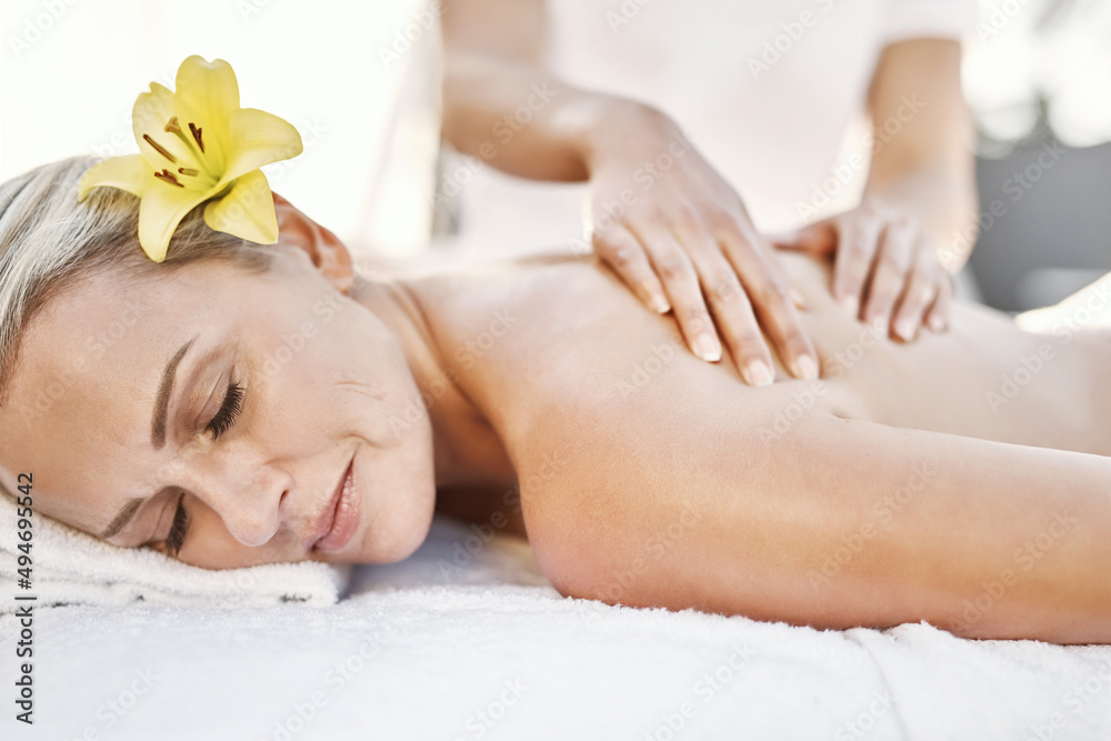 Vacations are the best. Shot of a relaxed middle aged woman lying on her stomach while receiving a m