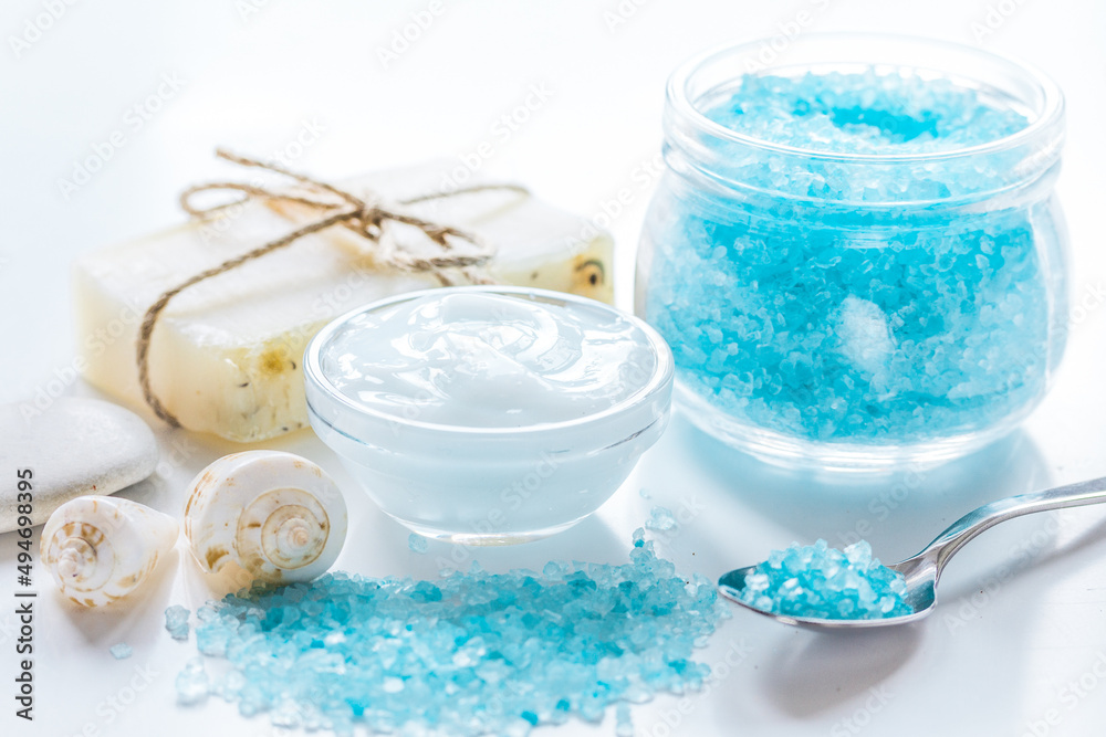 Home cosmetic with cream and blue sea salt on white background