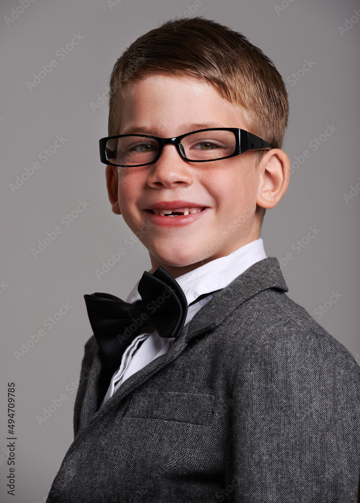 Hes a great dresse. Studio shot of a cute young boy wearing a retro suit against a grey background.