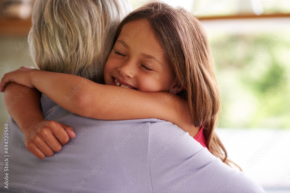 Giving granny a big hug. Shot of a cute little girl hugging her grandmother.