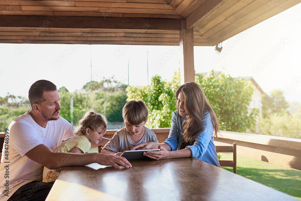 Theyre a connected family. Shot of a family using a digital tablet together outdoors.