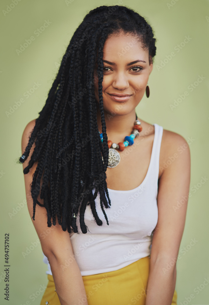 Draped in gorgeous dreads. Portrait of an attractive young woman posing against a green background.