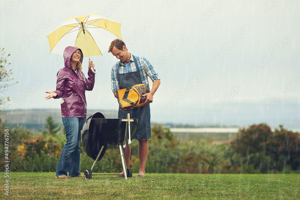 我们随时随地烧烤。一对情侣在雨中快乐烧烤的镜头。