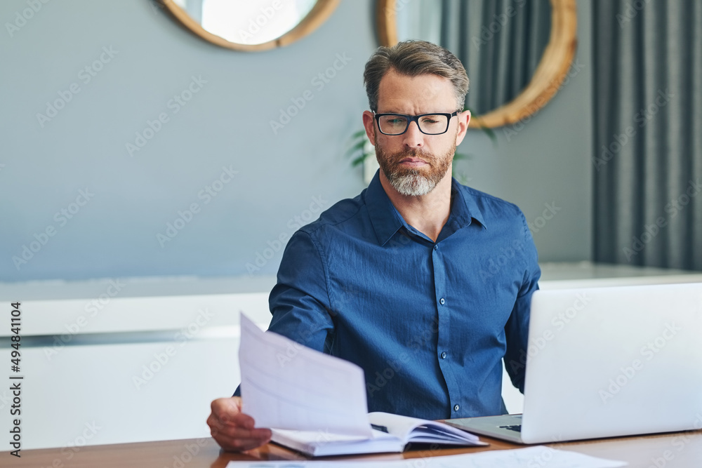 This looks like an important document. Shot of a focussed middle aged businessman sorting out docume