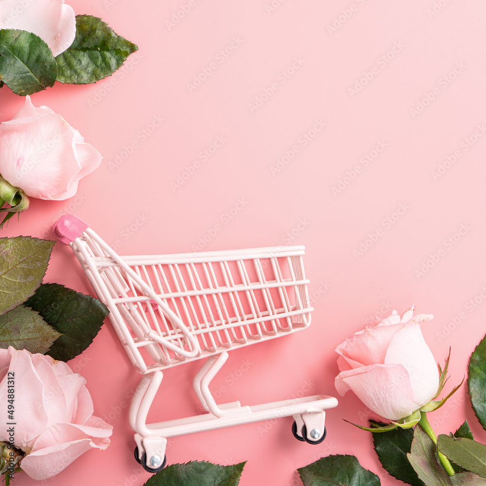 Mothers Day shopping design concept background with pink rose flower and cart on pink background.