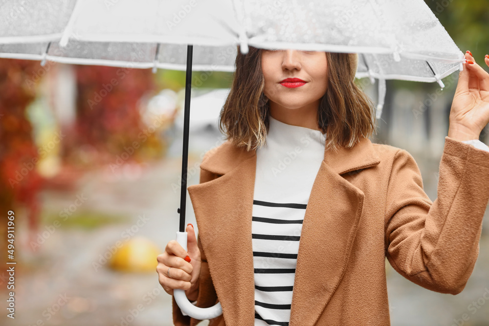 雨天拿着雨伞涂着红色口红的女人