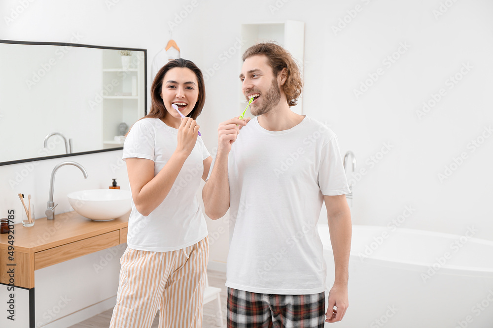 Lovely couple brushing teeth in bathroom