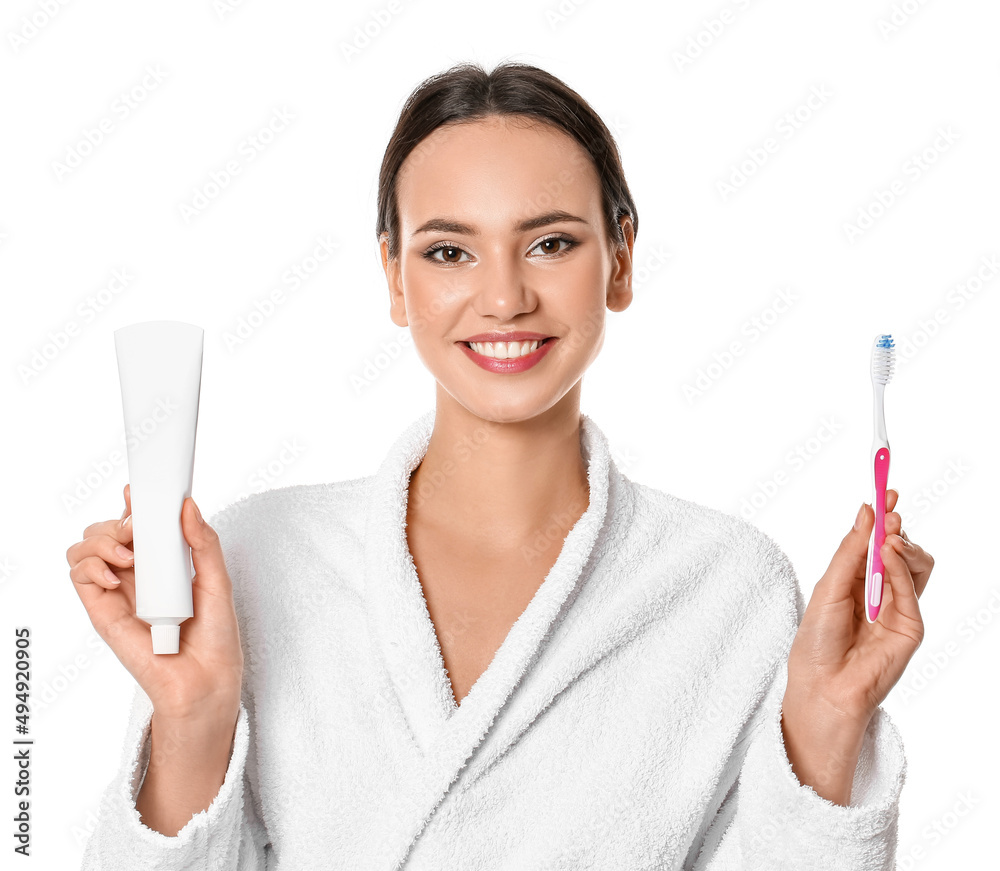 Smiling young woman with tooth paste and brush on white background