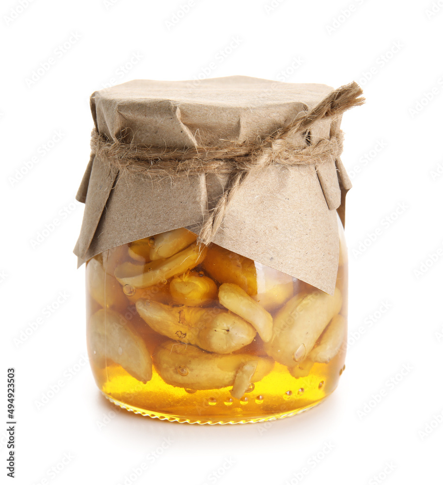 Jar of tasty cashew nuts with honey on white background