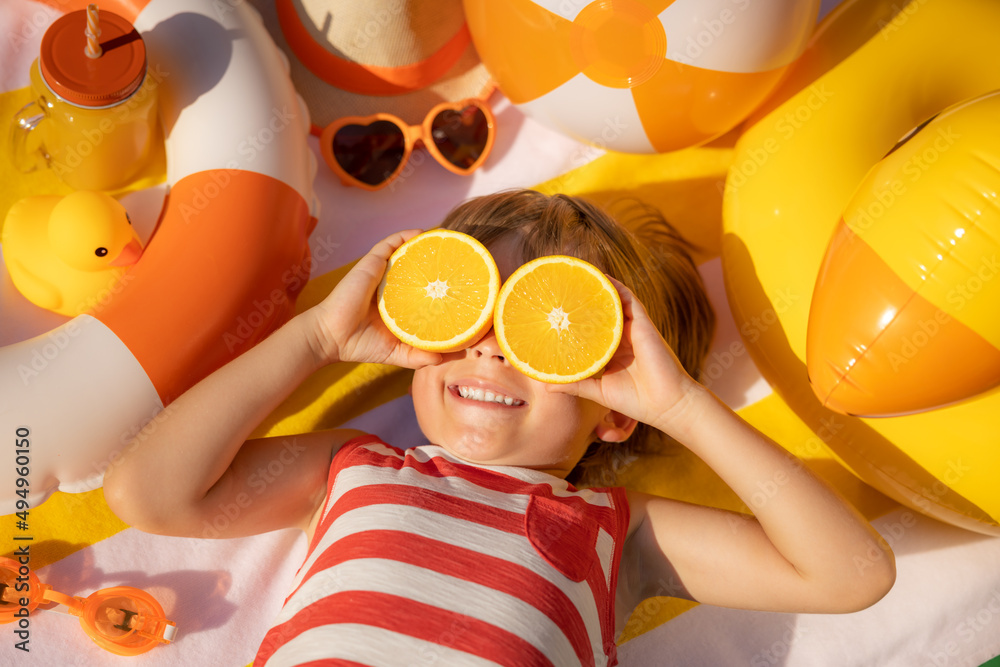 Happy child lying on beach towel