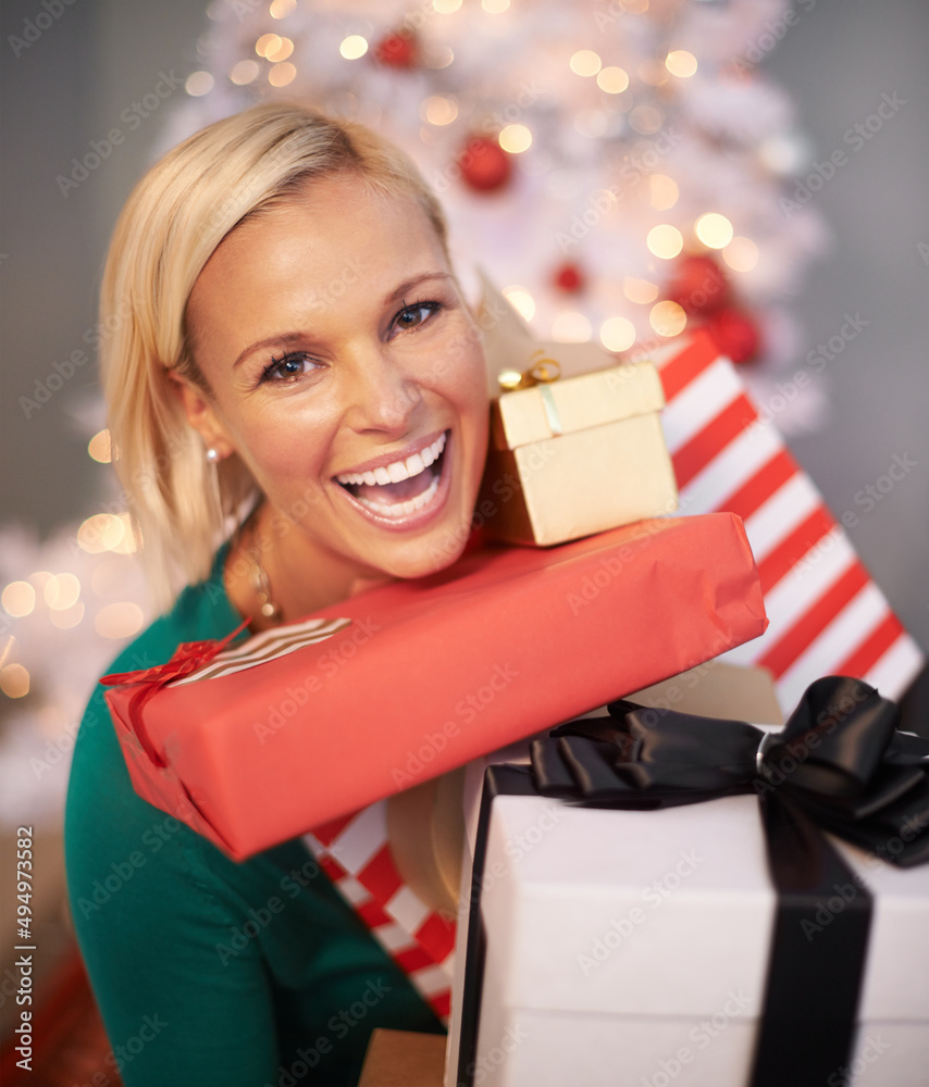 Ive been spoiled this Christmas. Portrait of an attractive young woman holding her Christmas gifts.