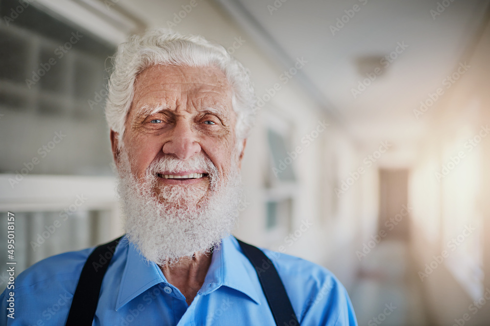 Retirement suits me like a glove. Portrait of a happy senior man posing in the hallway of his nursin