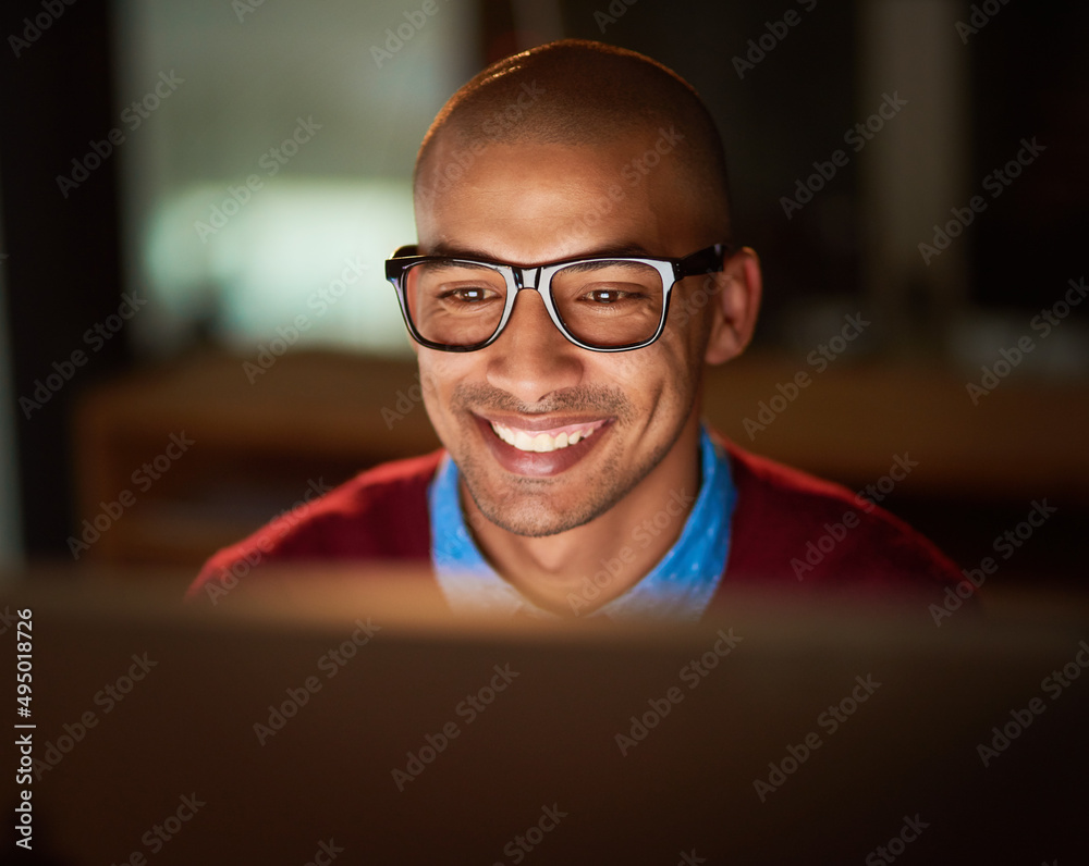 Impressing himself. Shot of a handsome young man working late in his office.