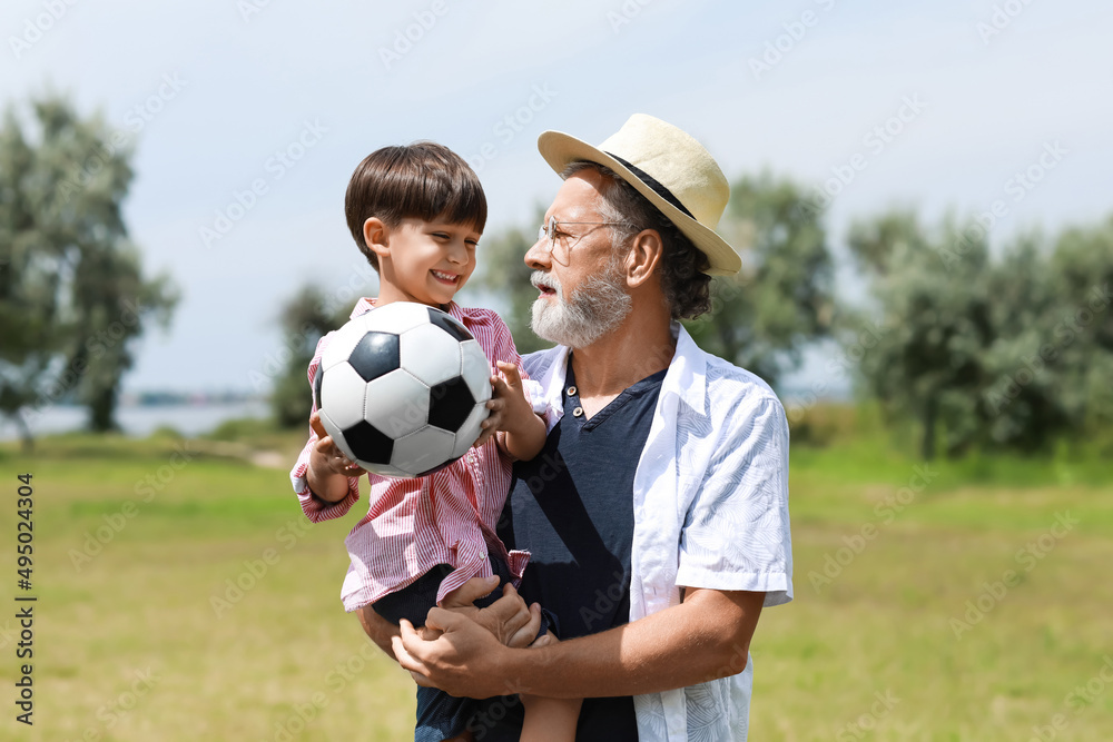 带球的小男孩和他的祖父在户外