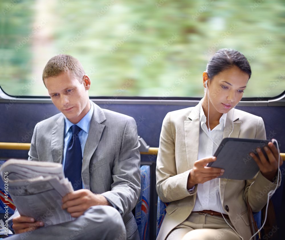 Optimizing their travel time wisely. Two business people reading catching up on the news on their co