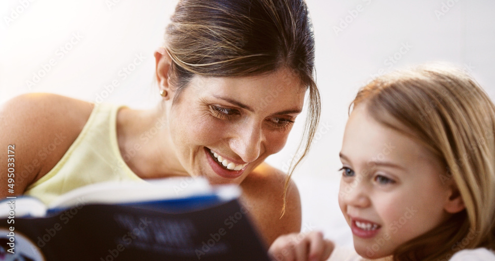 We share a similar love for books. Shot of a beautiful young mother reading a book with her daughter