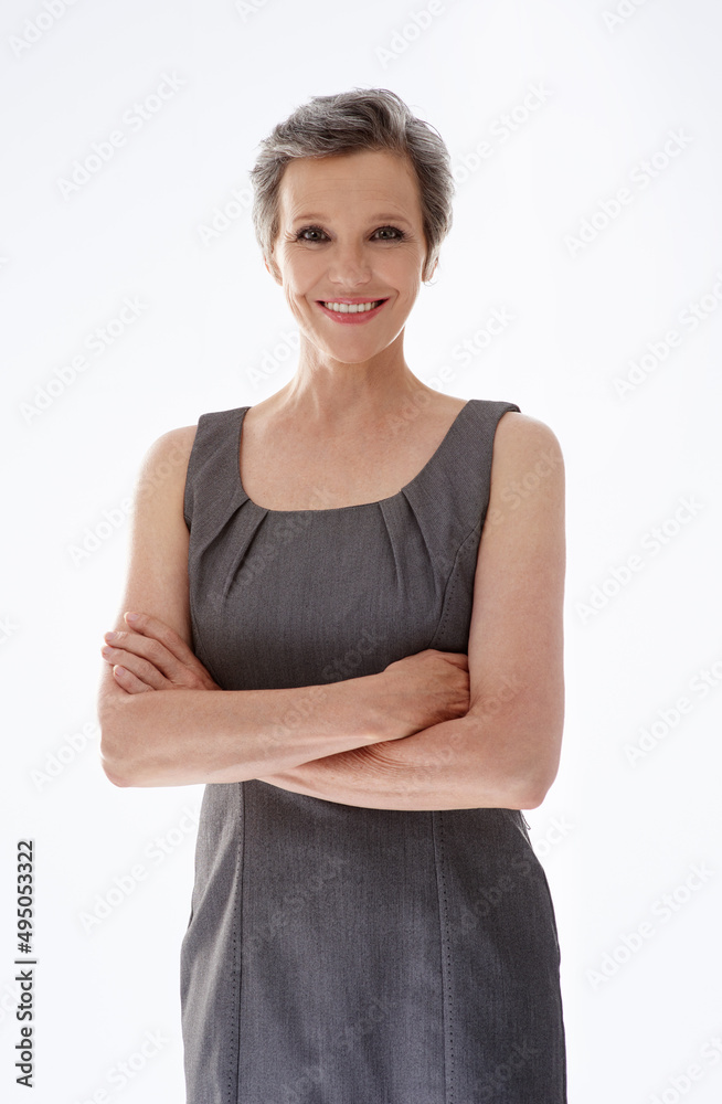 Elegant business style with a smile. A confident mature businesswoman standing against a white backg