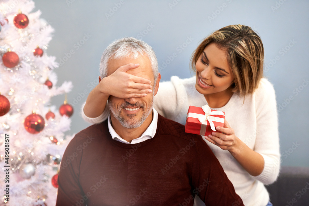 Giving him something special this Christmas. Shot of a young woman surprising her father with a Chri