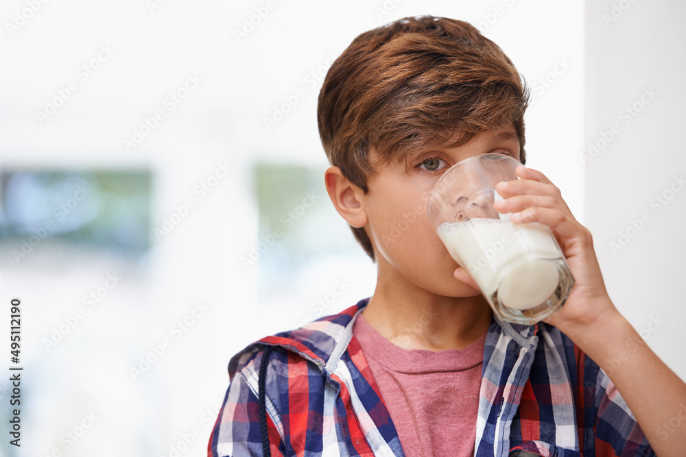 Ah... delicious. A young boy drinking a glass of milk.